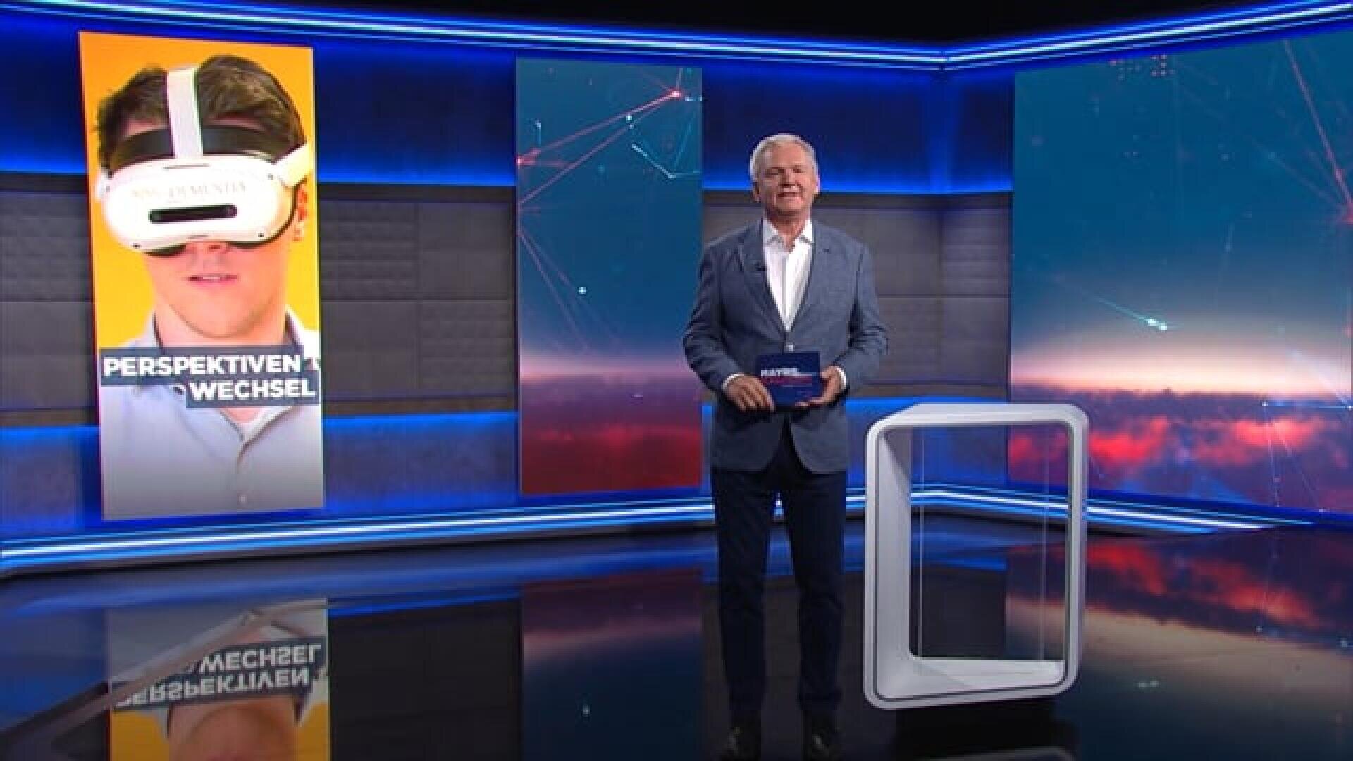 Un studio de télévision où se trouve un présentateur en costume, tenant une carte à la main. Derrière lui, sur un grand écran, on aperçoit une personne portant un casque de réalité virtuelle, accompagnée de l'inscription « CHANGEMENT DE PERSPECTIVE ». Le plateau est baigné d'un éclairage moderne bleu et violet.