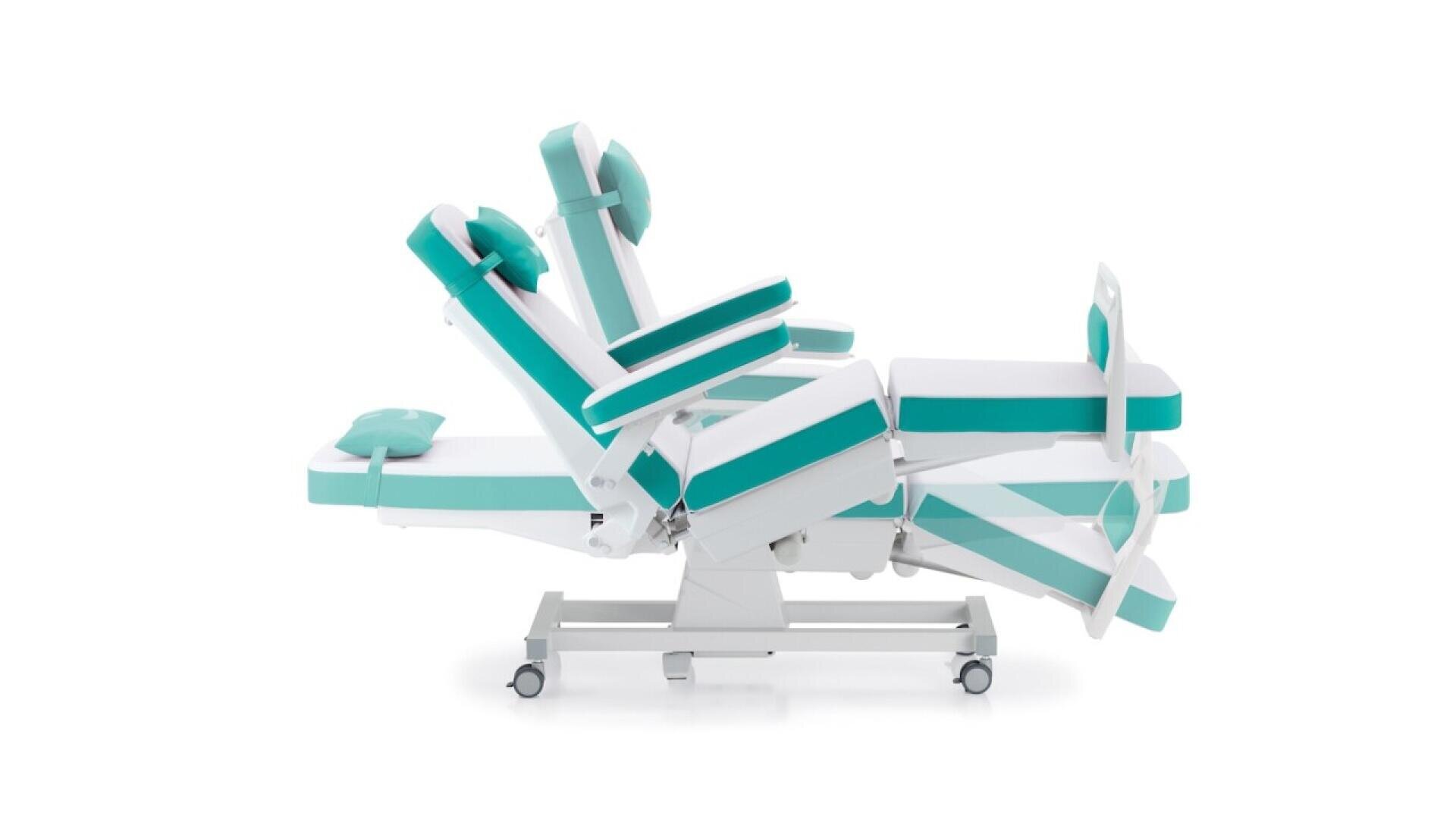 Fauteuil médical réglable en blanc et sarcelle avec plusieurs sections rembourrées pour la tête, le dos, les bras, l'assise et les jambes, en position inclinée sur fond blanc. Le fauteuil est monté sur roulettes pour la mobilité.