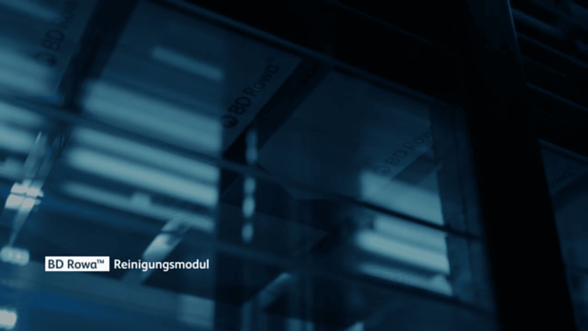 Ansicht des automatischen BD Rowa® Lagersystems mit Regalen und Boxen, teilweise verdeckt durch blaue Beleuchtung. Der Text in der unteren linken Ecke lautet BD Rowa® Reinigungsmodul.
