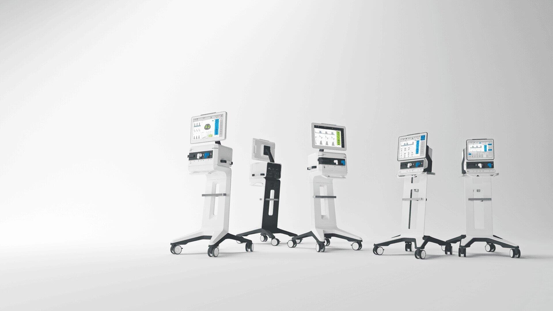 Fünf moderne medizinische Beatmungsgeräte mit Bildschirmen und Rädern sind in einer Reihe auf weißem Hintergrund angeordnet und zeigen verschiedene Blickwinkel und Designs der Geräte.
