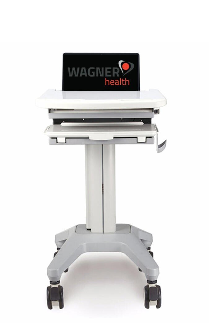 Ein medizinischer Rollwagen mit Rädern, einer weißen Tischplatte und einem Laptop, auf dessen Bildschirm das Wagner-Health-Logo zu sehen ist.