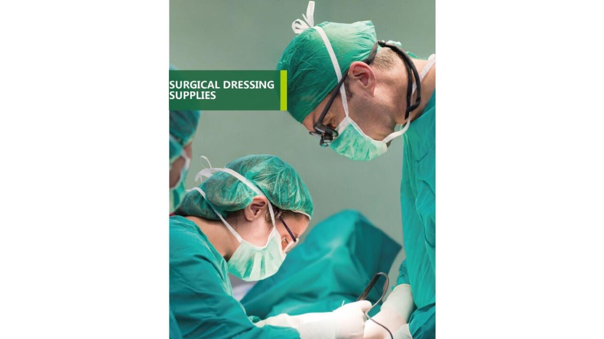 Deux chirurgiens portant des blouses, des masques et des bonnets verts se concentrent sur une procédure dans une salle d'opération. À l'arrière-plan, un panneau vert indique "Surgical Dressing Supplies" (fournitures pour pansements chirurgicaux).