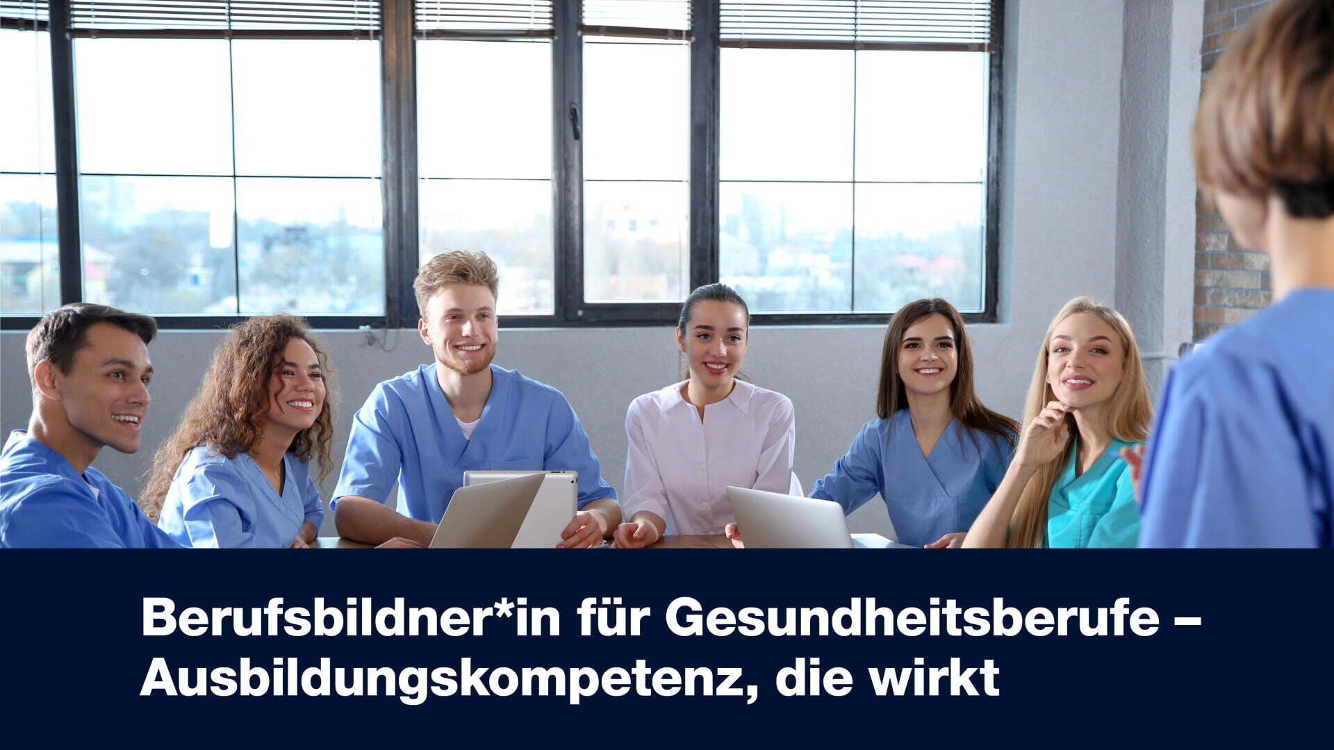 Eine Gruppe junger Erwachsener in blauen OP-Kitteln sitzt an einem Tisch, lächelt und hört einer Person zu, die vor ihnen steht. Der Text wirbt für die Ausbildungskompetenz von Ausbildern in Gesundheitsberufen auf Deutsch.