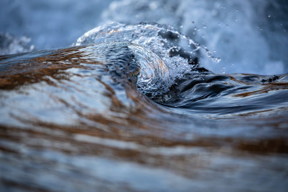 Water concept - river water flowing with light reflecting of its surface
